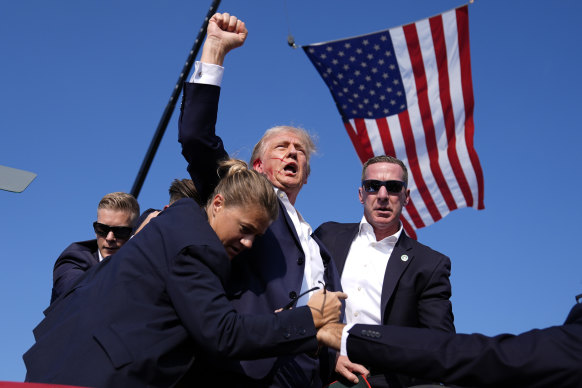 Republican presidential candidate former President Donald Trump is surrounded by US Secret Service agents at a campaign rally.