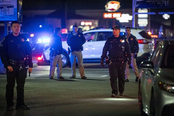 Police officers in the car park near the scene of the shooting.