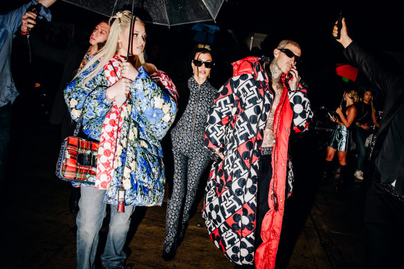 Alabama Luella Barker, Kourtney Kardashian and Travis Barker arrive at Tommy Hilfiger ready-to-wear runway front row at New York Fashion Week in the rain.