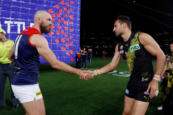 Max Gawn and Toby Nankervis shake hands before the sides run through a shared banner.