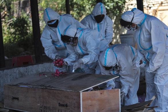 Family members perform the last rites for a COVID-19 victim at a crematorium in Jammu, India on Sunday.