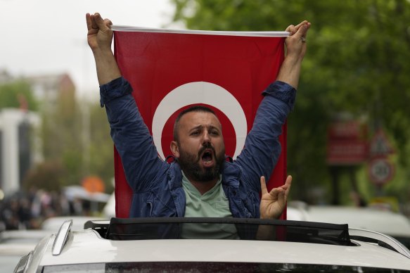 A supporter of President Recep Tayyip Erdogan holding a Turkish flag shouts slogans outside AK Party offices in Istanbul, Turkey.