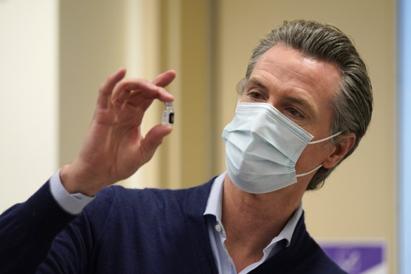 California Governor Gavin Newsom holds up a vial of the Pfizer-BioNTech COVID-19 vaccine.