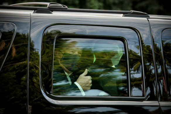 Trump gives a thumbs up as he is driven past supporters outside Walter Reed National Military Medical Centre, where he was being treated for COVID-19 in October.