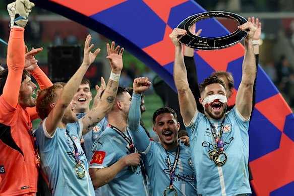 Mathew Leckie holds up the A-League championship trophy.
