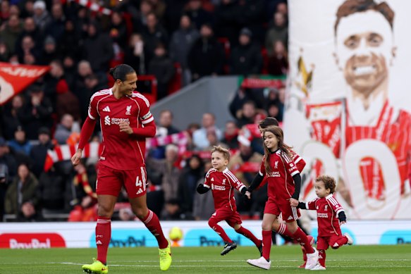 Liverpool captain Virgil van Dijk of Liverpool enters the pitch with Diogo Jota’s sons Dinis (left) and Duarte (right) at Anfield.
