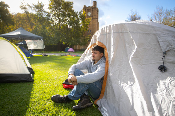 Nabil Hassine inside his tent on the lawn at the University of Melbourne.