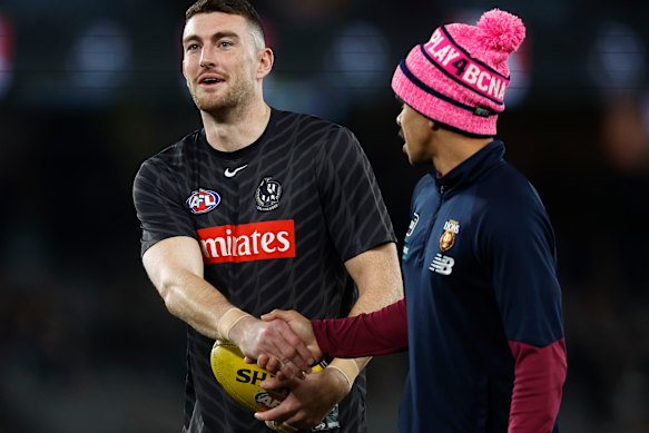 Friends after all: Collingwood’s Daniel McStay with Brisbane’s Charlie Cameron.