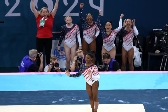 Simone Biles of Team United States reacts after finishing her routine in the floor exercise while teammates Jade Carey, Jordan Chiles, Hezly Rivera and Sunisa Lee cheer.