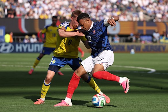 Kylian Mbappe #10 of France is challenged by Daniel Svensson #8 of Sweden.
