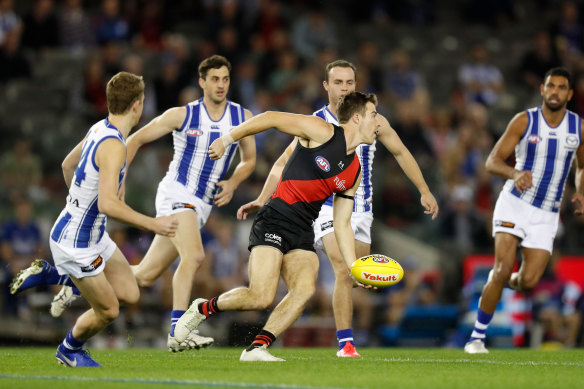 Zach Merrett looks to get the ball away for the Bombers.