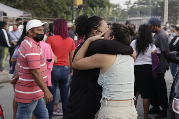 Women hug while waiting for news about their relatives who are inmates at the prison.