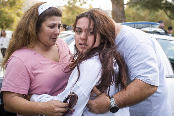 Keegan Burns, 16, seeks the comfort of her parents Mirasol and Jim following the shooting at Santa Clarita.