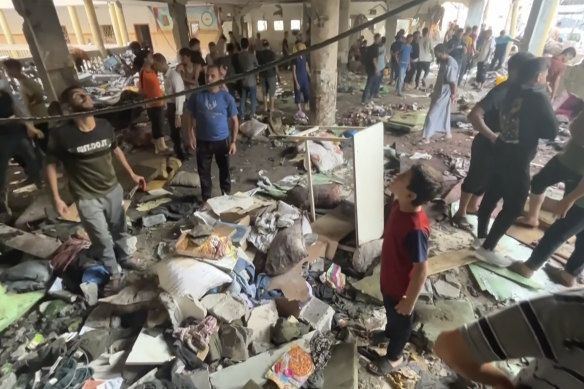 People inspect the damage at a school after being hit by an Israeli airstrike in Gaza on Saturday.
