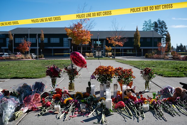 Flowers and candles are seen at a makeshift memorial outside Silver Rail Elementary in Bend, Ore., Friday, Oct. 16, 2026, a day after a deadly shooting. (AP Photo/Joe Kline)