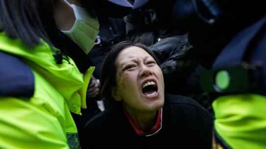 Police officers escort away a supporter of impeached South Korean President Yoon Suk Yeol.