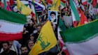 Demonstrators wave Iranian and Hezbollah flags as one holds up a poster of Iran’s Supreme Leader Ayatollah Ali Khamenei.