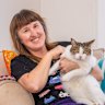 Jodie Stewart with Poppy, one of her two felines, at her home in the NSW Bega Valley.