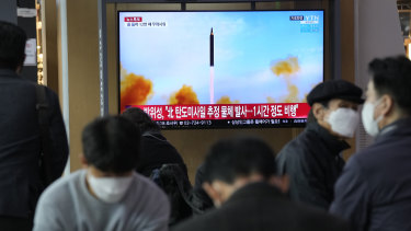 People watch a TV showing a file image of North Korea’s missile launch during a news program at the Seoul Railway Station in Seoul, South Korea, on Thursday.