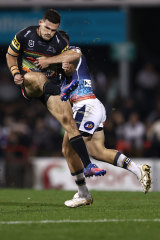 Nathan Cleary is hit hard by Reece Robson after kicking the ball.
