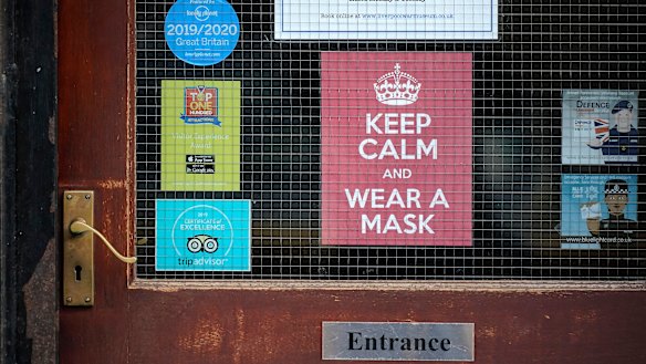 A 'Keep Calm And Wear A Face Mask' sign adorns a door in central Liverpool.