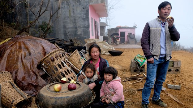 'It was a bitter experience': Xia Dayun, 33, with his wife Xu Xuanhua and their children outside the concrete house built with his earnings from migrant labour in Xinjiang.