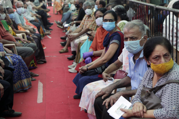 People wait to receive COVID-19 vaccine in Mumbai, India, on Thursday. Several states have reported running out of vaccine doses.