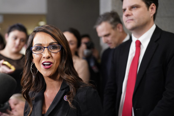 Representative Lauren Boebert speaks as Representative Matt Gaetz listens.