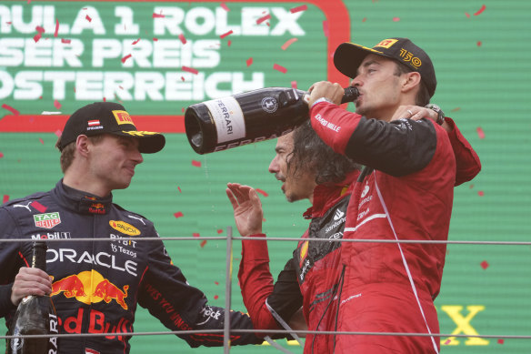 Charles Leclerc (right) celebrates his win on the podium.