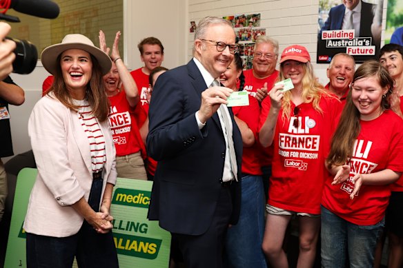 Albanese flashes his Medicare card while campaigning with France in Dickson.