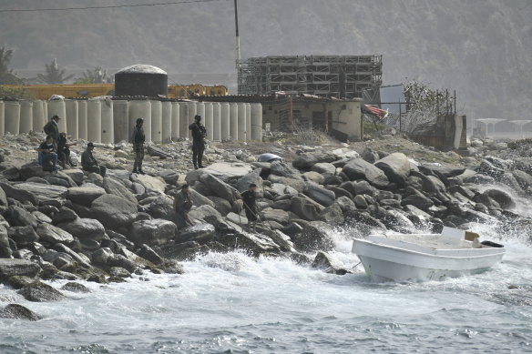 Security forces guard the shore area and a boat in which authorities claim a group of armed men landed in the port city of La Guaira, Venezuela.