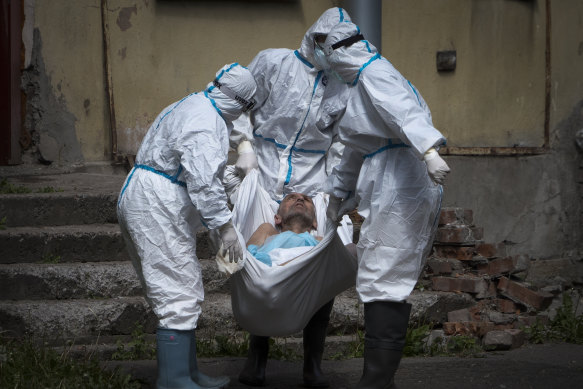 Medical workers wearing protective gear carry a patient at an infectious diseases hospital in Russia last year.