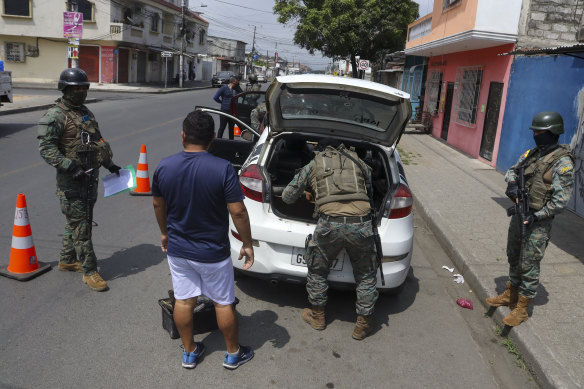 Soldiers inspect cars at a road block in Guayaquil, Ecuador.