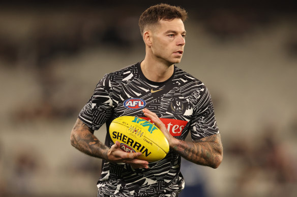 Jamie Elliott of the Magpies warms up.