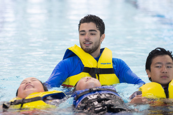 Alijan Ruiz teaches children to swim at Brimbank Aquatic and Wellness Centre.