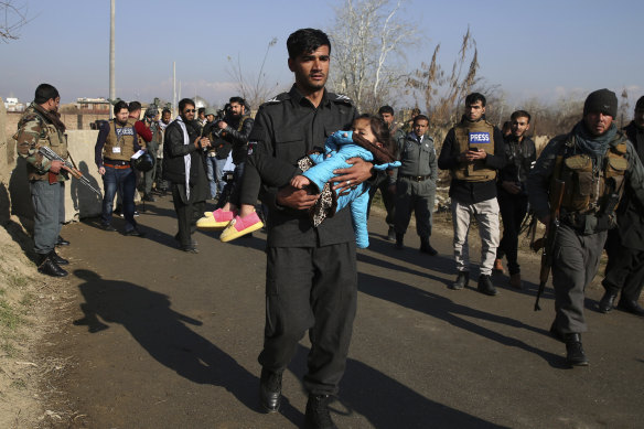 An Afghan security policeman carries his injured daughter after an attack near the US Bagram Air Base in Kabul.