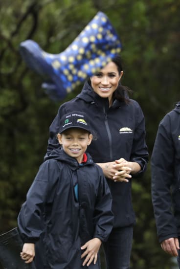 Meghan, Duchess of Sussex reacts with children from the Trees in Survival group in a 'gumboot-throwing' contest in Auckland. 