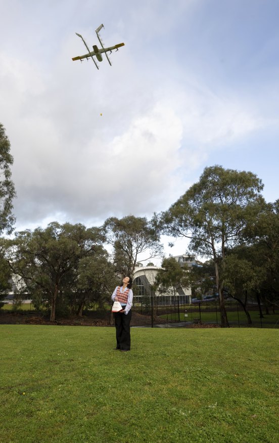 Dani Valent receiving a mango juice delivered via drone in Jubilee Park, Ringwood. 