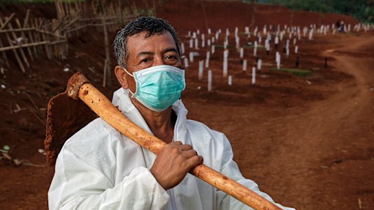 Pak Tuing, a grave digger at a public cemetery, rests at a public cemetery being expanded to accommodate rising COVID-19 deaths in Jakarta.