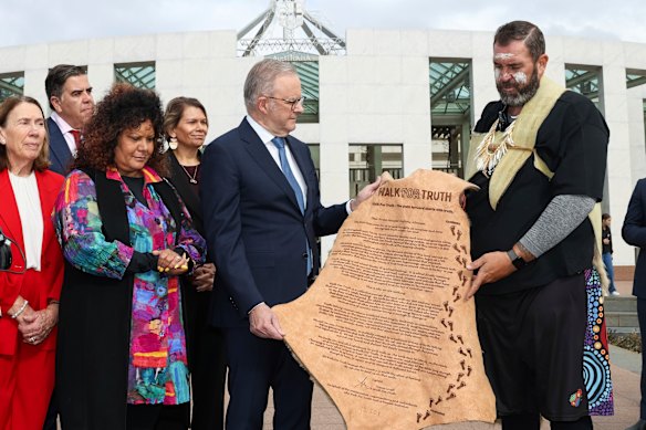 Prime Minister Anthony Albanese is presented with a letter written on kangaroo skin, urging the creation of a truth-telling process for national healing, by Travis Lovett, a Kerrupmara Gunditjmara man who is executive director of the University of Melbourne's Centre for Truth Telling and Dialogue, and former deputy chair of the Yoorrook Justice Commission.