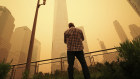 A man pauses to look at the smoke and haze shrouding One World Trade Centre building in New York City.