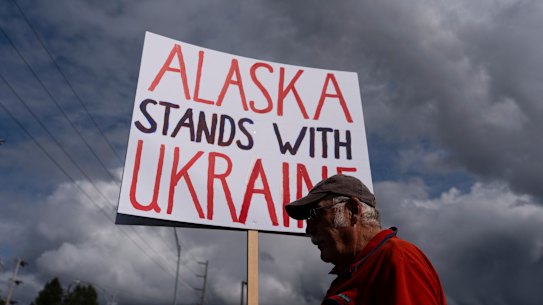 Dug Loshbaugh holds a sign during a rally in Anchorage on Thursday, ahead of the Trump-Putin meeting.