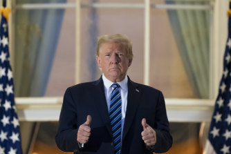 President Donald Trump gives a thumbs up as he stands on the Blue Room Balcony upon returning to the White House. 