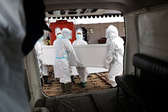 Health workers carry a coffin containing the body of a COVID-19 victim in East Java, Indonesia in July.