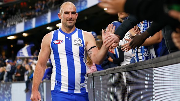 Ben Cunnington high fives North Melbourne fans.