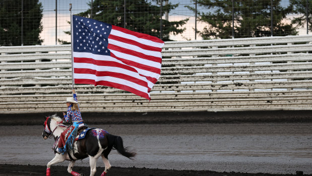 A sense of relief may be premature: a woman on horseback carries an American flag during the national anthem prior to a NASCAR event in in Knoxville, Iowa. 