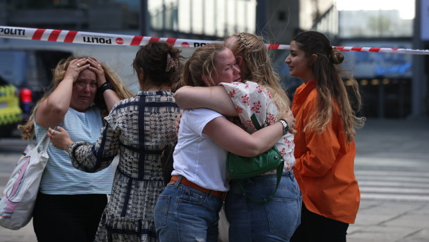 Shocked shoppers comfort each other at Field’s Centre in Copenhagen after the shooting.