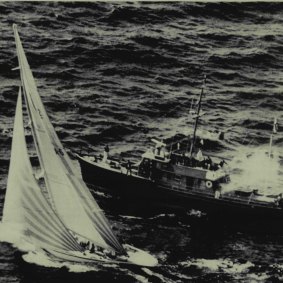 A puff of smoke indicating the end of the race rises from committee boat Black Knight as Australia II crosses the line to win the sixth America's Cup race, Thursday, to tie the best-of-seven series at 3-3, and send the competition, for the first time, into a seventh race, September 22, 1983.