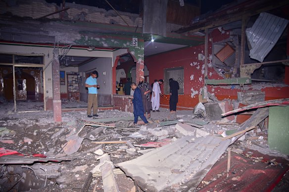 Residents and media in a building damaged by a suspected Indian missile attack near Muzaffarabad, Pakistan, on Wednesday.