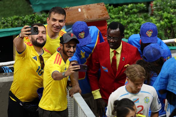 Colombia fans pose for photos with DR Congo fan Michel Nkuka Mboladinga, also known as Lumumba Vea.
